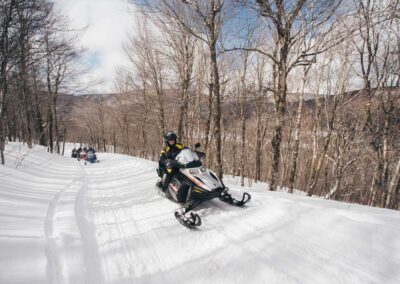 Snowmobiling on local wooded trails